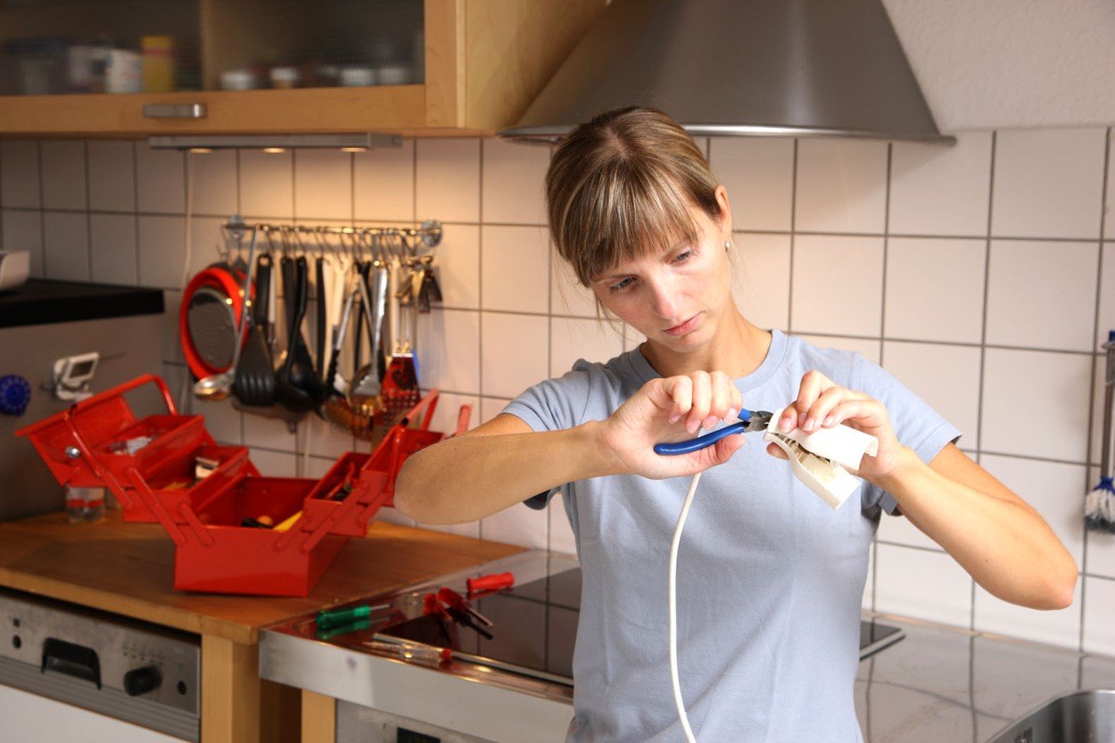 žena majstoripe, popravlja u kuhinji